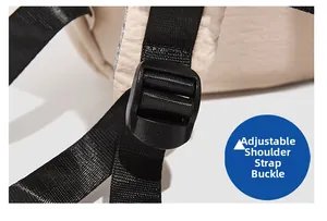 Detail of adjustable black shoulder strap buckle on cream minimalist backpack