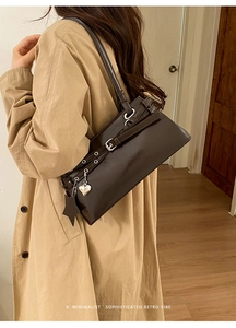 Détail du sac Boston en cuir marron foncé avec breloque cœur et pendentif étoile chic