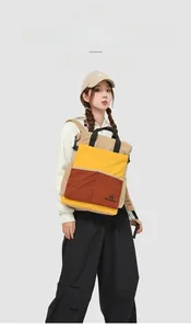 Détail d'un sac à dos tendance avec design color-block, deux poches et poignée de transport