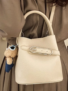 Elegante cremeweiße Bucket Bag aus Leder mit süßem Bärenanhänger für Frühjahrsmode