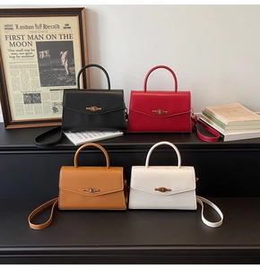 Row of retro leather handbags in black, red, brown, and white colors with gold buckles