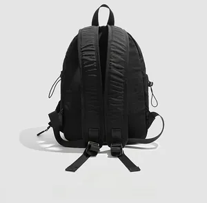 Back view of black lightweight nylon hiking backpack with padded straps and side drawstrings