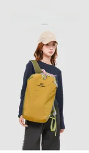 Zaino da viaggio leggero in nylon giallo presentato da un modello in esterno