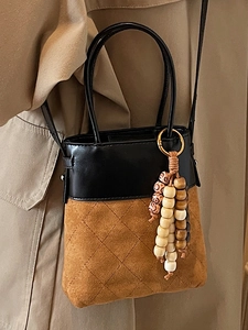 Quilted bucket bag in black leather and brown suede with stylish beaded tassel