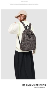 Side view of leopard print backpack with adjustable straps worn by a model in a studio