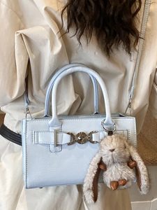 Sac bandoulière en cuir verni bleu clair avec boucle métallique et breloque lapin