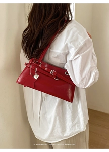 Détail du sac vintage rouge avec pendentifs d'étoiles argentées sur chemise blanche
