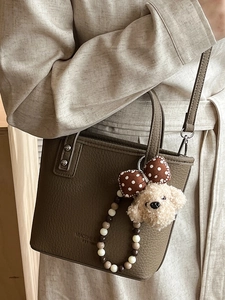 Chic dark brown lychee leather bucket bag with dog pendant and crossbody strap