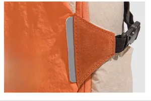 Close-up of high-density stitching and contrasting orange nylon fabric on outdoor backpack