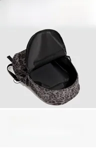 Macro view of leopard print backpack interior showing spacious main compartment and pockets