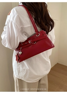 Détail du sac Boston en cuir rouge avec breloque cœur et pendentif étoile sur la bandoulière