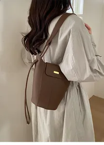 Sac seau marron grainé avec plaque métallique dorée et détails de couture