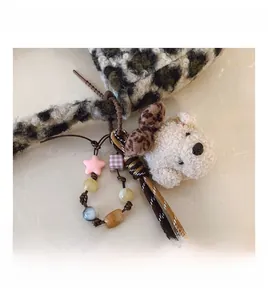 Detail of leopard mohair bag accessory featuring a plush teddy bear head and star beads