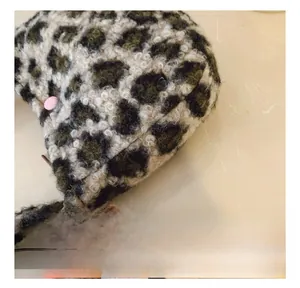 Detailed close-up of leopard print plush bag featuring neat stitching and pink snap button
