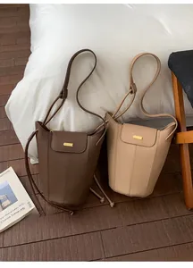 Détail des sacs seaux en cuir grainé marron et beige avec boucles métalliques élégantes