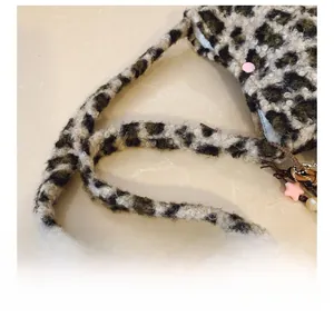 Close-up of leopard print plush shoulder bag with thick strap and pink star charm