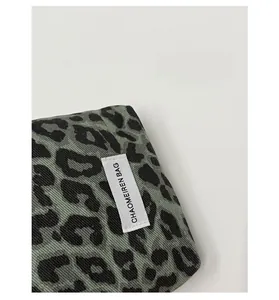 Gros plan sur la texture du tissu léopard vert et noir avec étiquette de logo cousue