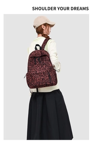 Detail view of large leopard print backpack with black handle and side adjustable buckles