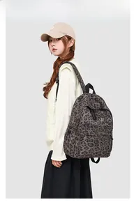 Detail view of leopard print backpack showing large capacity and zipper front pocket