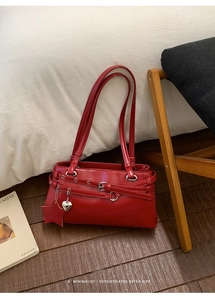 Détail du sac à bandoulière en cuir verni rouge avec pendentifs étoile et cœur rétro