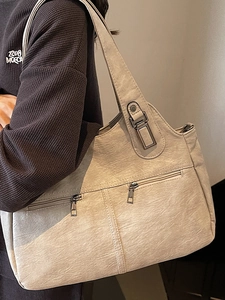 Chic beige textured PU leather tote bag with dual front zippers and side-worn model view