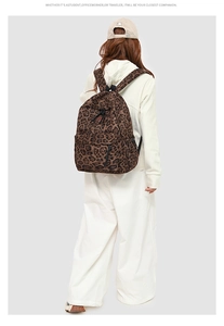 Detail view of the leopard print backpack on a model showing back fit and straps
