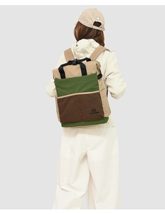 Détail d'un sac à dos en toile tricolore avec panneaux kaki, vert olive et marron foncé
