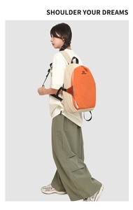 Side view of beige and orange color-block backpack worn by a model in studio setting