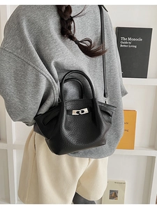 Détail d'un sac seau en cuir noir grainé avec des boucles en métal argenté élégant