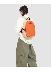 Detail view of the contrasting orange and beige backpack with durable stitching and top handle