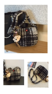 Detail of plaid plush crossbody bag featuring red button accents and a cute bear charm