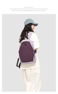 Side view of woman wearing a large purple contrast color backpack with top handle