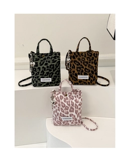 Détail de mini sacs cabas léopard en vert, jaune et rose avec pendentifs en forme de cœur