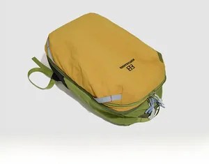 Dettaglio dello zaino da esterno in nylon leggero con pannelli giallo verdi e logo