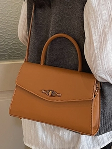 Chic vintage caramel leather crossbody bag with top handle and retro gold twist lock