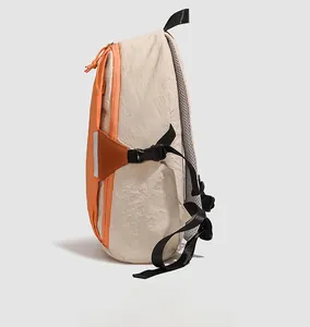 Detail of high-capacity orange nylon backpack side showing buckle and breathable mesh