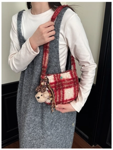 Close-up of red and white plaid plush shoulder bag with cute teddy bear charm