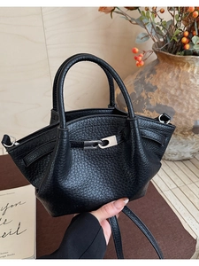 Détail d'un sac seau en cuir grainé noir avec fermoir métallique argenté et poignée haute