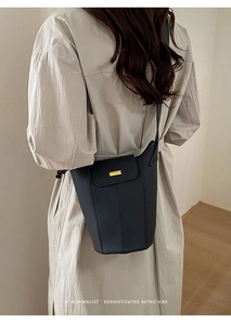 Détail du sac seau vintage en cuir noir avec boucle métallique dorée élégante