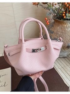 Détail du mini sac seau en cuir rose à grain litchi avec fermoir en métal argenté brillant