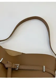 Close-up of brown leather bucket bag showing litchi texture and silver hardware