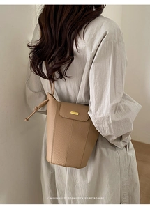 Sac seau chic en cuir grainé abricot avec plaque en métal doré et bandoulière