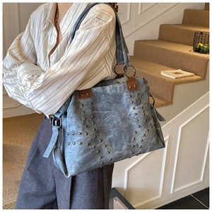 Detail of vintage rivets in V-shape on retro tote bag with large metal ring and strap