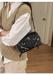 Detail der schwarzen Leder-Bikertasche mit silbernen Reißverschlüssen und Metallschnallen
