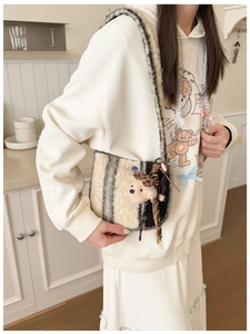 Detailed view of striped plush crossbody bag with a cute 3D stuffed bear and woven tassel