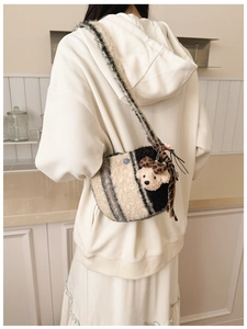 Detail of plush crossbody bag with black and beige stripes and leopard bear pendant