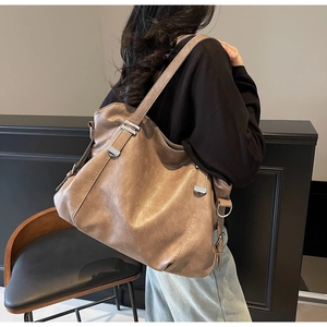 Détail d'un sac cabas vintage kaki foncé montrant le cuir PU souple et la boucle argentée