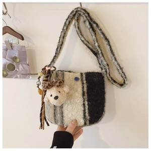 Detail of soft leopard faux fur bag featuring a cute teddy bear charm and colorful tassels