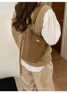 Vue détaillée d'un sac seau en cuir marron avec un fermoir rectangulaire doré chic