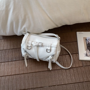 Detail der weißen Vintage Boston Bag mit Silberschnallen und Quasten auf Holzoberfläche